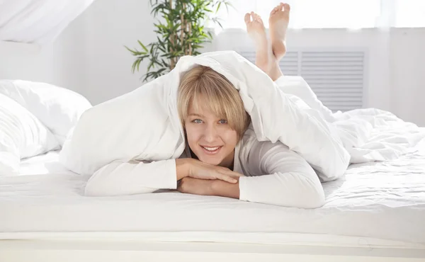 Schöne Mädchen am Morgen im Bett mit Blick auf die Kamera — Stockfoto