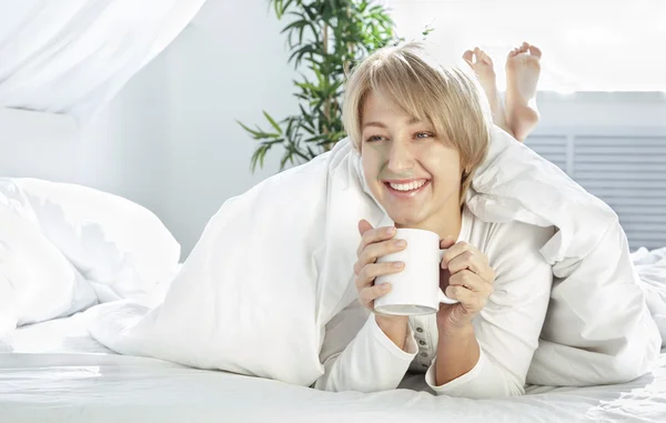 Beautiful girl in the morning in bed with cup — Stock Photo, Image
