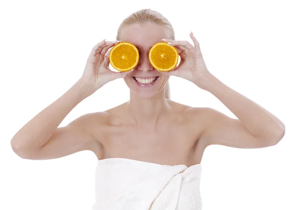 Beautiful girl in spa salon holds two halves of oranges in the e — Stock Photo, Image