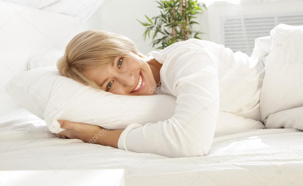 beautiful girl in a white bed in the morning, smiling