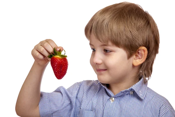 漂亮的白人男孩看着成熟的草莓 — 图库照片
