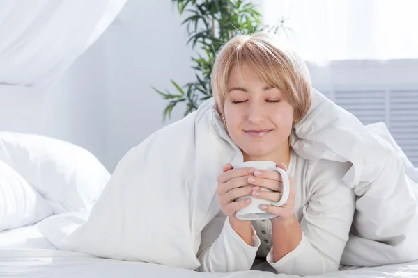 Beautiful woman in bed in the morning, with a cup — Stock Photo, Image