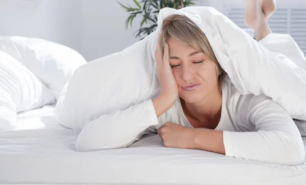 Junge Frau morgens im Bett, zu wenig Schlaf. lizenzfreie Stockfotos