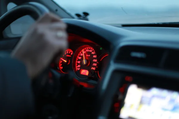 Bilen hastighetsmätare och en hand — Stockfoto