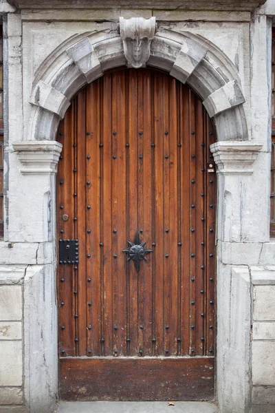 Porta in legno con telaio in pietra intagliata — Foto Stock