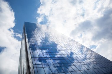 Skyscraper against blue sky clipart