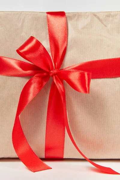 明るいグレーの背景を持つお祝いのギフトボックス上のシルクリボンからのクローズアップビューの大きな赤い弓 グリーティングカード — ストック写真