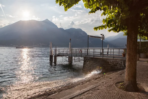 Vista do lago Como no pôr do sol com cais na Itália — Fotografia de Stock