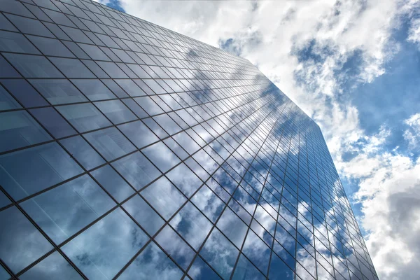 Mrakodrap s odrazem modré oblohy a mraky青い空と雲の反射で高層ビル — Stock fotografie