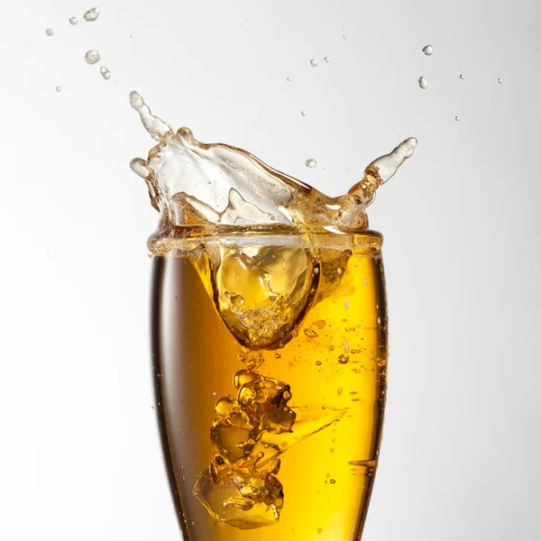 Salpicos de cerveja em vidro isolado em branco — Fotografia de Stock
