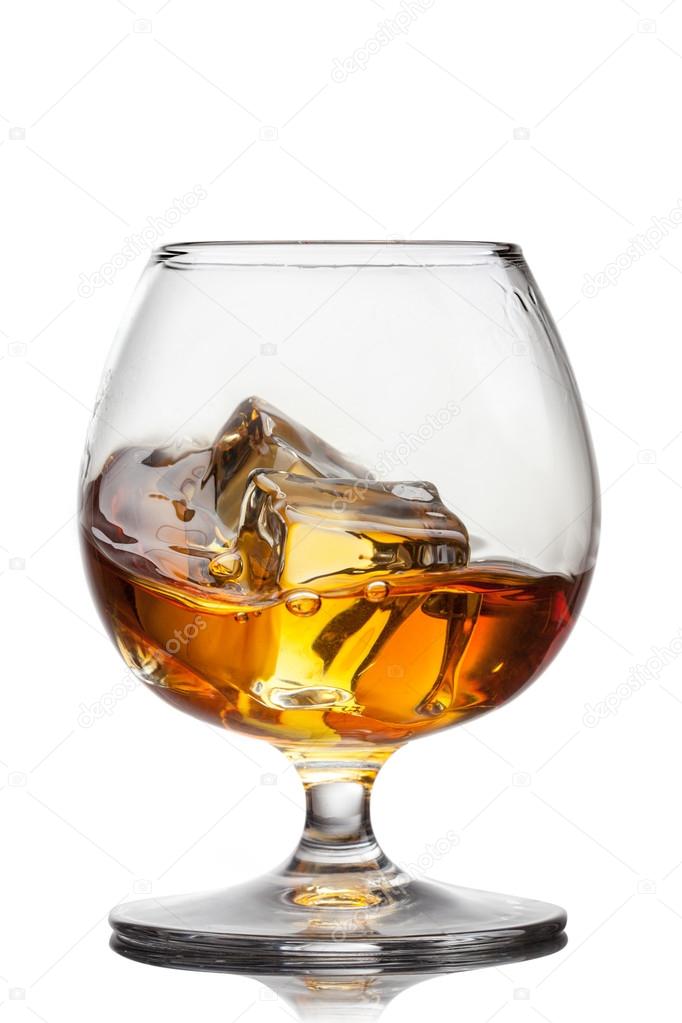Splash of whiskey with ice in glass isolated