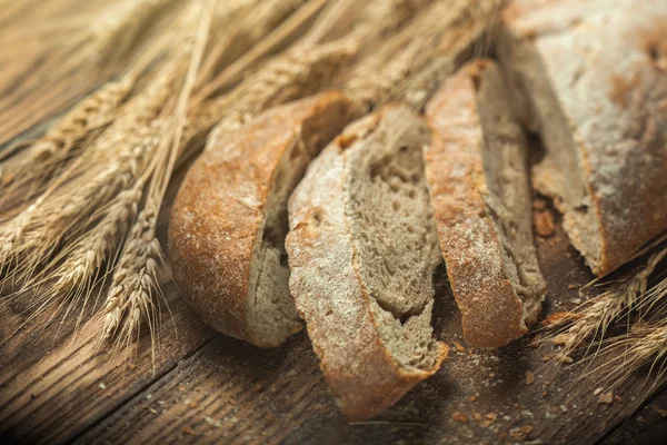 Chleb i pszenica na drewnianym stole, płytki DOF — Zdjęcie stockowe