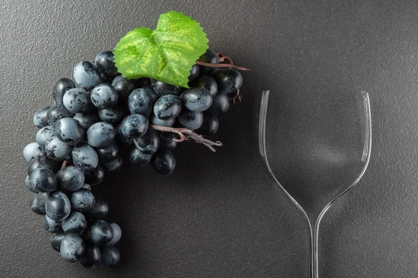 Wine glass made of forks and grape on black — Stock Photo, Image