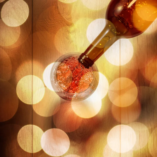 Vin rouge versé dans le verre de la bouteille sur une table en bois blanc. T — Photo