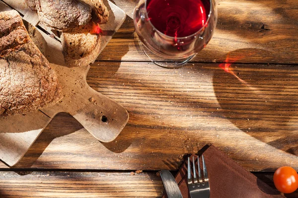 Draufsicht auf Wein und Brot auf serviertem Holztisch — Stockfoto