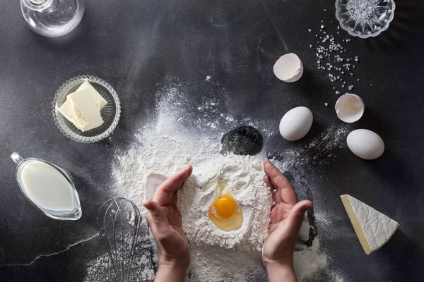 Womans hands knead dough on table with flour — Stock Photo, Image