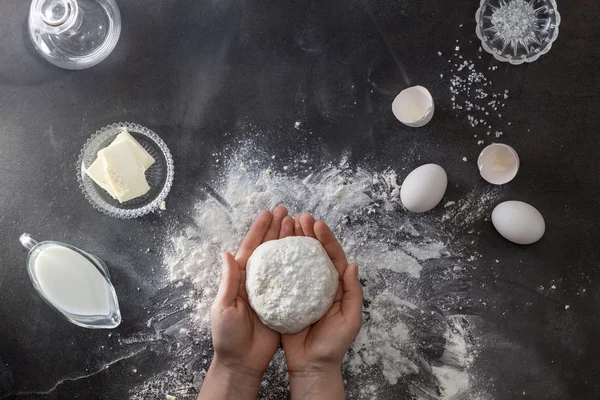 Womans hands knead dough on table with flour — Stock Photo, Image