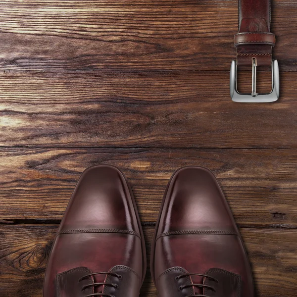 Classic male brown leather shoes with belt on wood — Stock Photo, Image