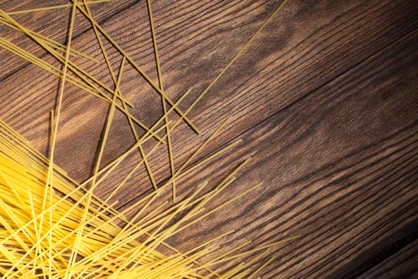 Italian spaghetti on wooden background — Stock Photo, Image