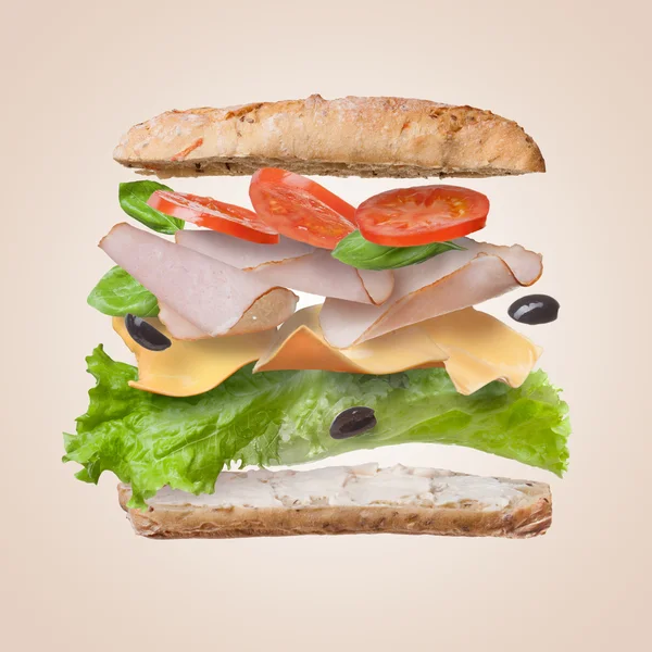 Sanduíche com ingredientes em queda no ar — Fotografia de Stock