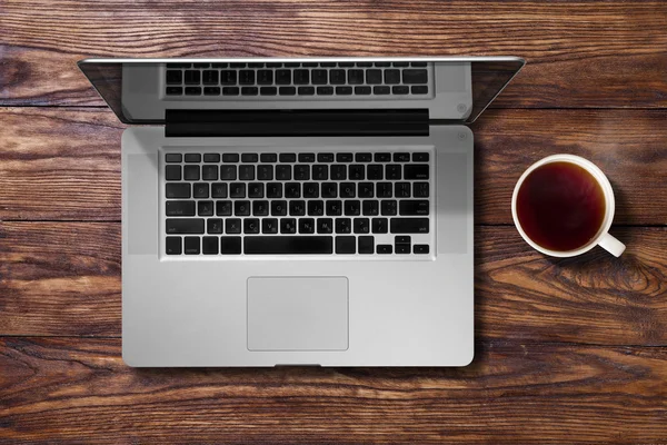 Open laptop and cup of tea — Stock Photo, Image