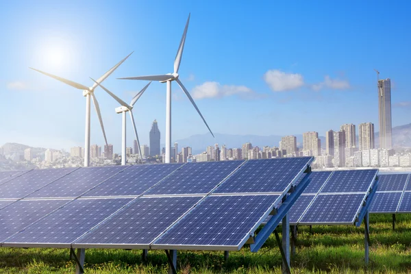 Zonnepanelen en windturbines met stad — Stockfoto