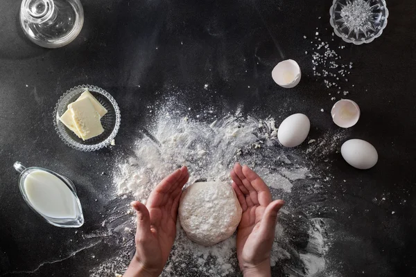 Womans hands knead dough on table with flour — Stock Photo, Image