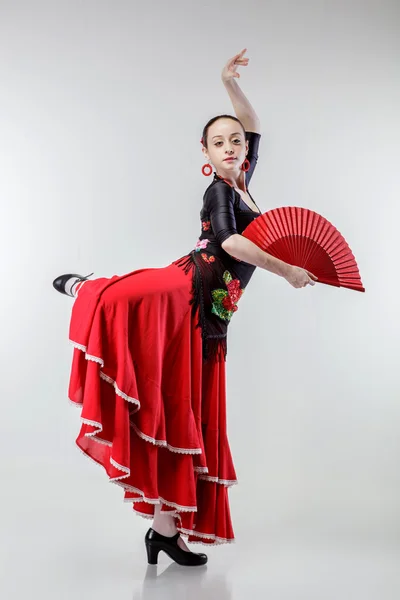 Молода жінка танцює фламенко в червоній сукні на білому — стокове фото