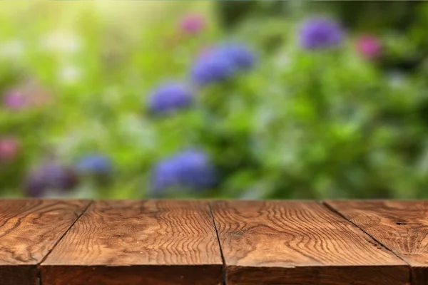 Holztisch und farbige Hortensienblüten auf dem Rücken — Stockfoto
