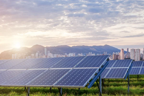 Painéis solares com cidade no fundo — Fotografia de Stock