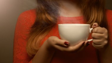 gülümser ve sicak tutan kadın