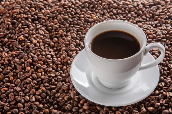 Witte kopje zwarte koffie op bonen — Stockfoto