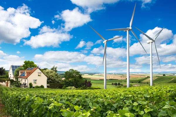 Huizen met zonnepanelen op het dak en wind turbines — Stockfoto