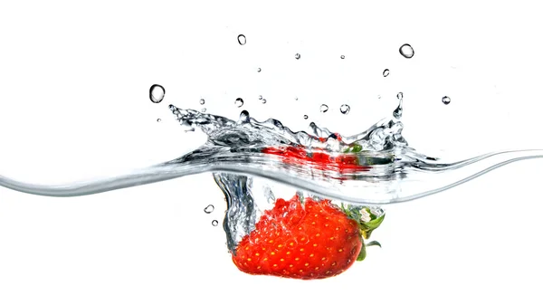 Färska jordgubbar har sjunkit i blått vatten med stänk — Stockfoto
