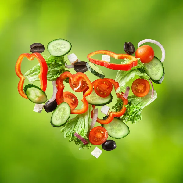 Salada voadora em fundo verde natural — Fotografia de Stock