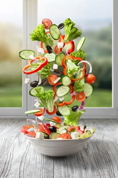 Salada voadora em madeira contra janela — Fotografia de Stock