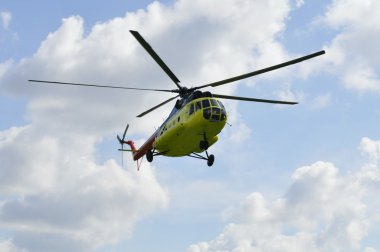 Sarı mi-8 helikopter bulutlar karşı uçar.