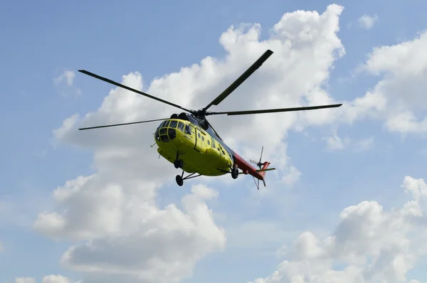 O helicóptero MI-8 amarelo voa contra as nuvens . — Fotografia de Stock