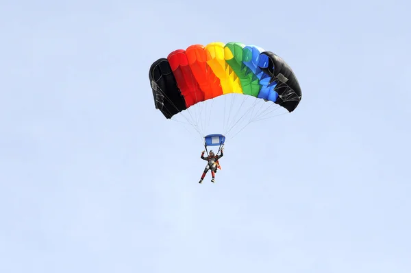 Paraşütçü çok renkli bir paraşüt aşağı gider. — Stok fotoğraf