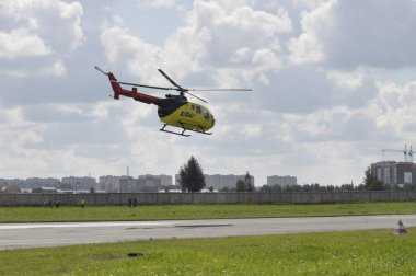 Tyumen, Rusya, 7 Ağustos 2018: Utair havayolu gökyüzünde küçük sarı helikopter