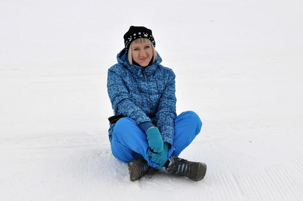 在冬天的衣服的女人坐在雪地上. — 图库照片