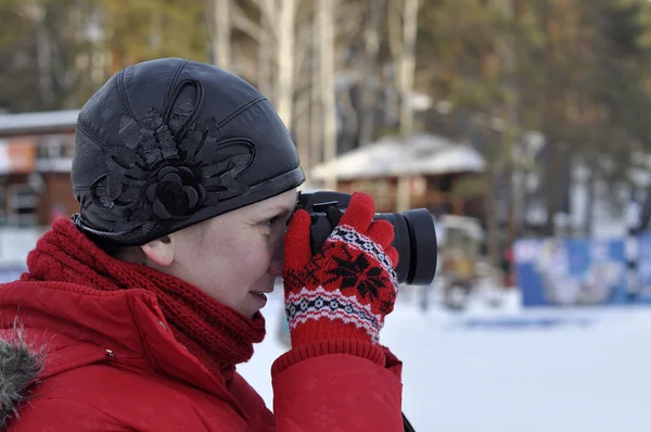 Kvinnan i vinterkläder fotografier Slr kameran. — Stockfoto