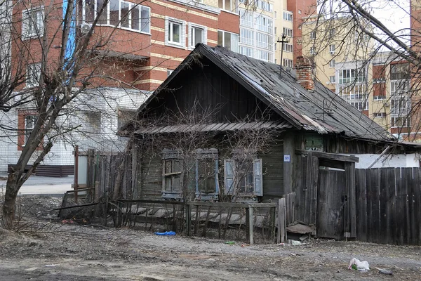 Staré dřevěné domy proti moderní výškové budovy. Tyumen, Ru — Stock fotografie