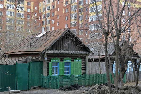 Staré dřevěné domy proti moderní výškové budovy. Tyumen, Ru — Stock fotografie