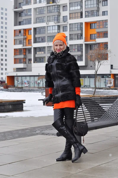 La mujer en el abrigo de piel cuesta contra los nuevos edificios —  Fotos de Stock
