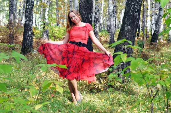 La belle femme en vêtements rouges dans le bois d'automne . — Photo