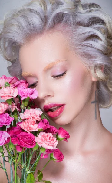 Blond kvinna med blommor — Stockfoto