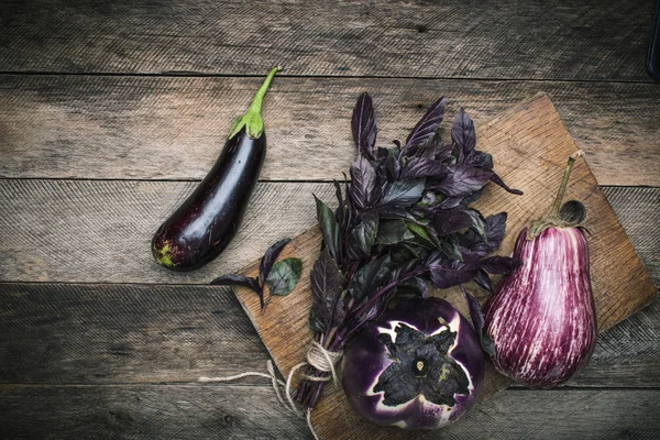 Aubergines et basilic sur planche à découper — Photo