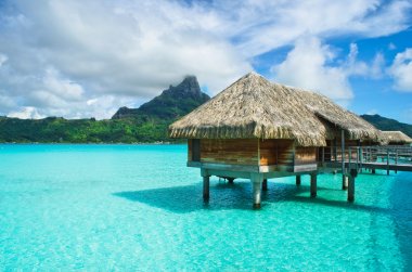 Thatched roof honeymoon bungalow on Bora Bora clipart