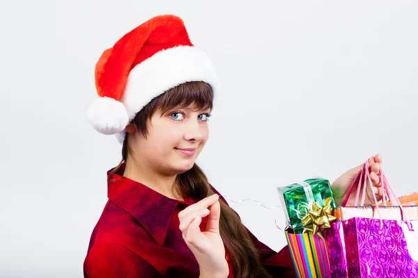 Blauwogige mooi meisje in Kerstman hoed met presenteert — Stockfoto